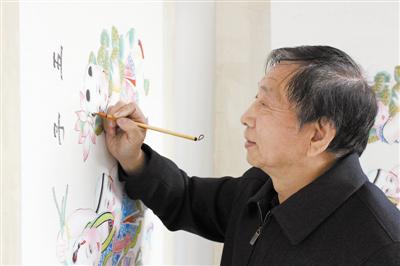 霍慶順在年畫《五子奪蓮》畫坯上進行彩繪創作