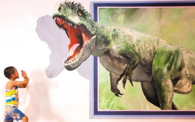 一小朋友在體驗恐龍一躍而出的3D藝術