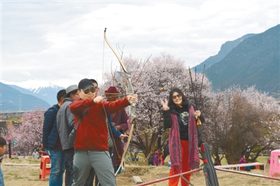 遊客在林芝鎮嘎拉桃花村體驗工布響箭