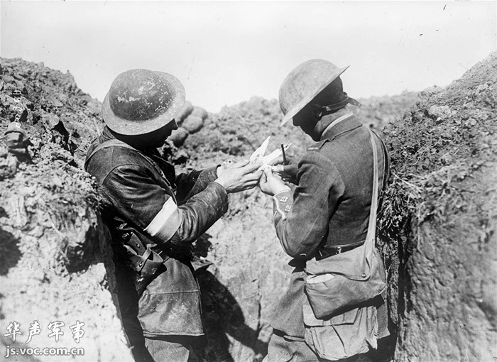 兩名英軍士兵正將一條情報綁在信鴿的腿上