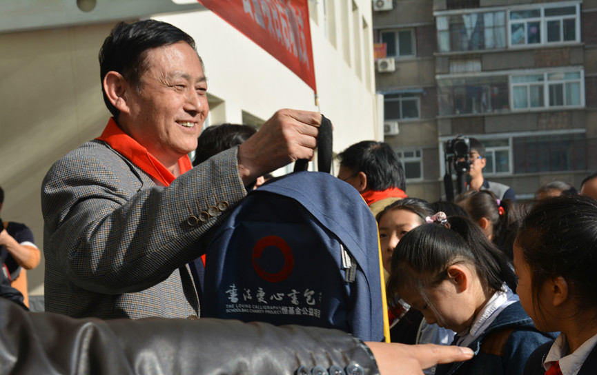理事長李恆濱先生為孩子們發放書法書包