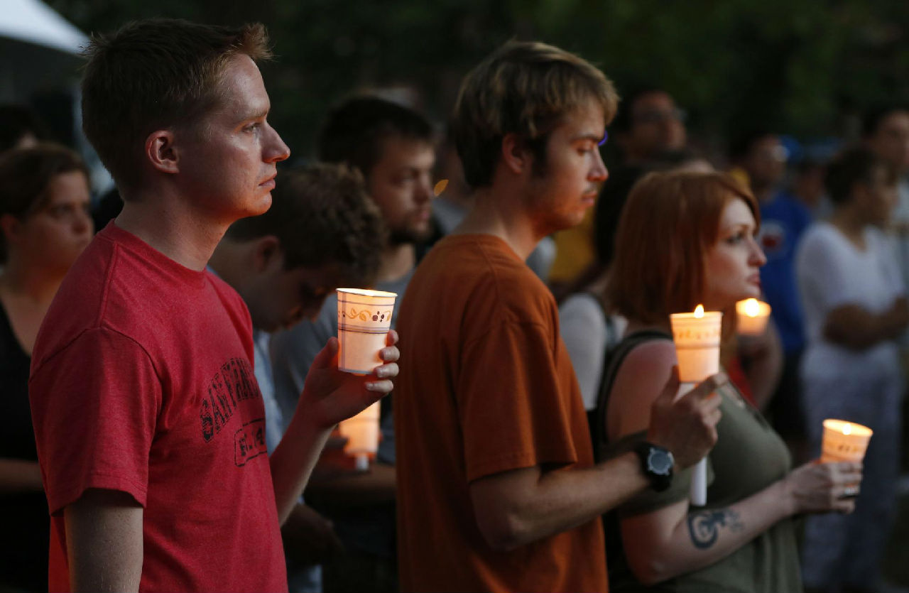 人們手持蠟燭在案發現場外舉行悼念活動