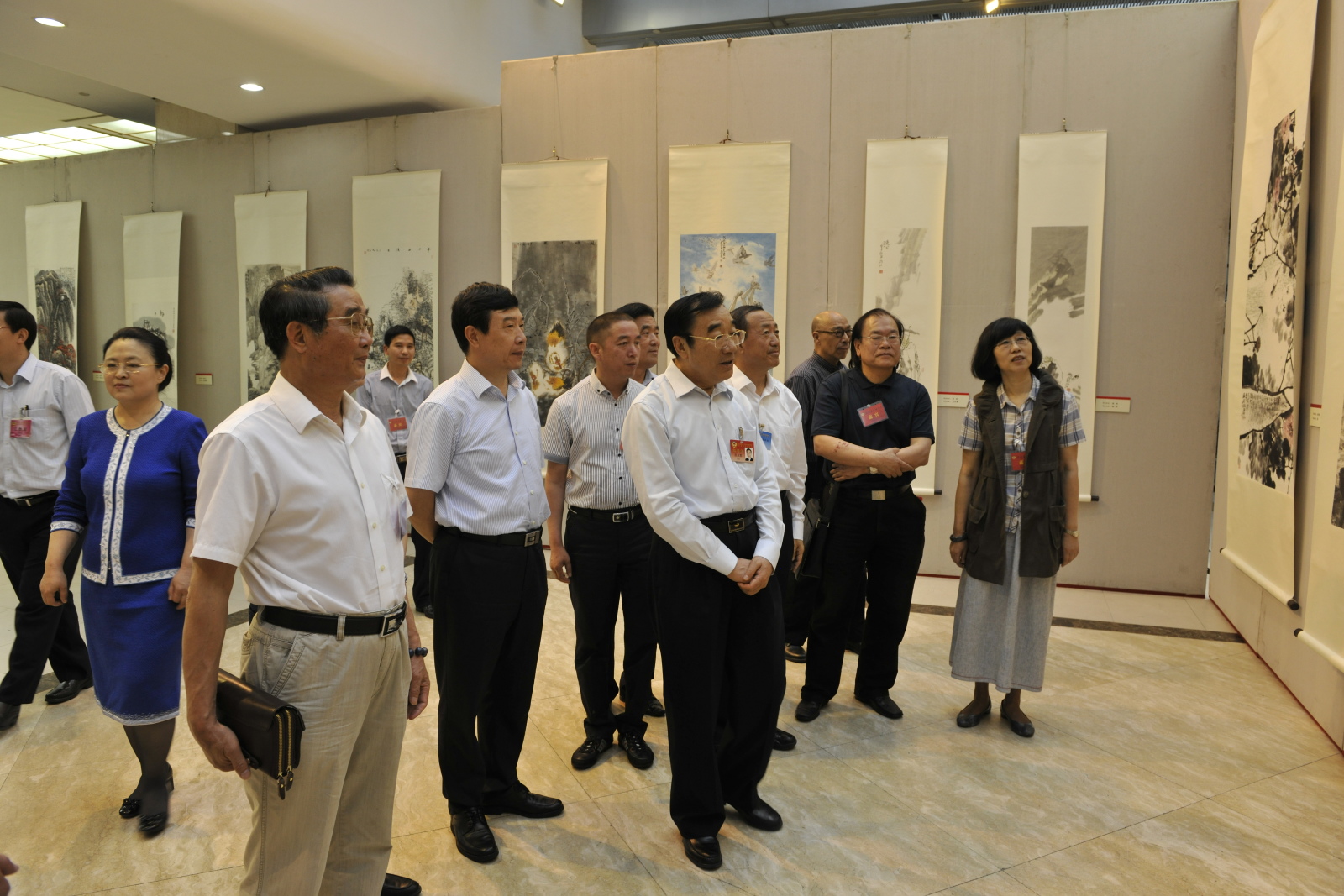 柴文達（前左一）陪同領導同志觀看書畫作品