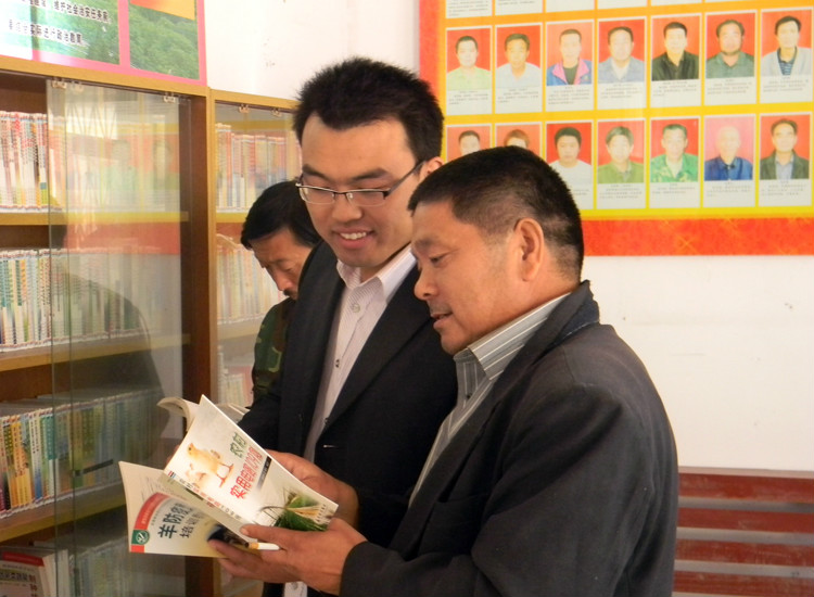 大學生村官李慶建與村民在村裡的農家書屋