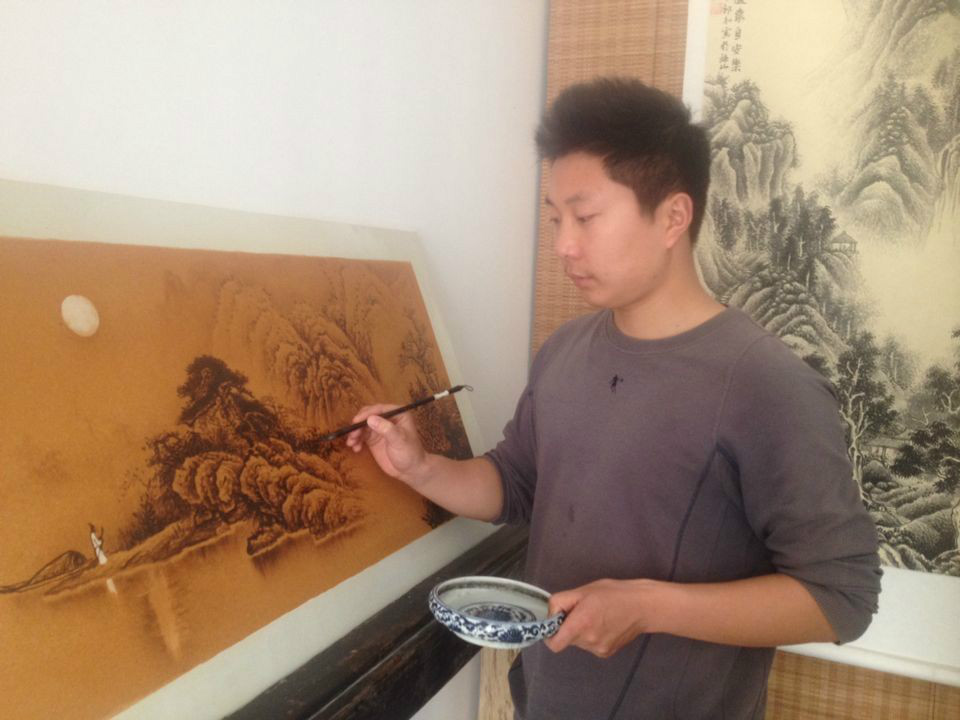著名青年陶瓷藝術家鄧利在瓷板上創作