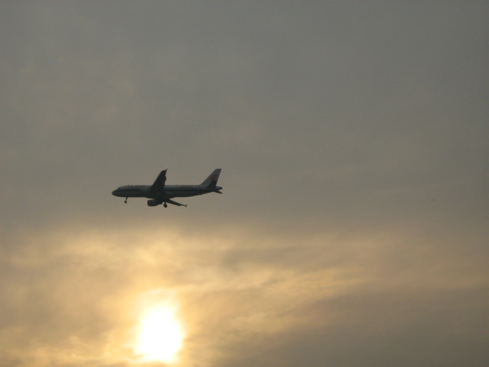 衝出霧霾。一架飛機正在降落首都國際機場。