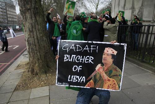 利比亞反政府示威者手舉諷刺卡扎菲的海報