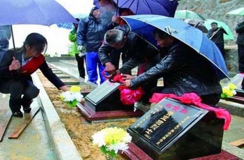 壺山陵園管理人員冒雨給烈士墓披上寄思花