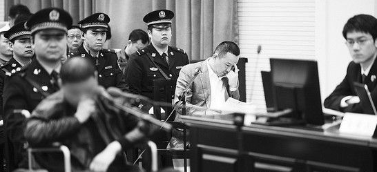 劉維(前中)等7名被告人被法警帶到法庭受審