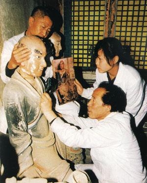 塑像復原技師（右下）正精心修復羅漢頭像