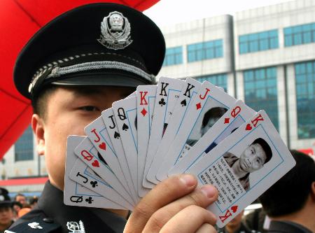 警察展示印有被通緝逃犯頭像的撲克牌