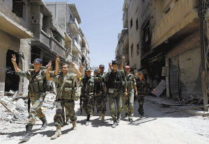 敘利亞政府軍士兵走過霍姆斯市哈利迪亞城區