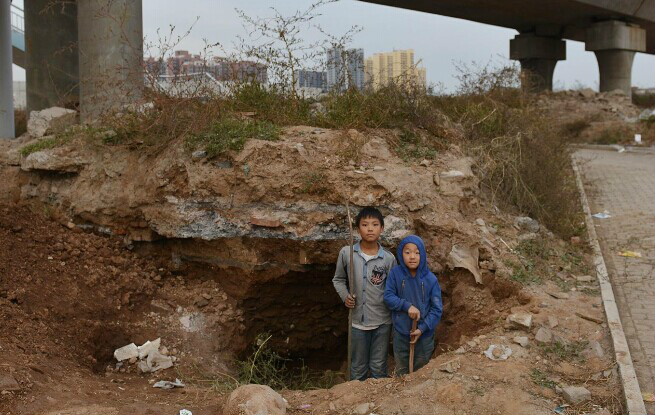 焦作山陽路橋下，孩子在文物挖掘洞玩耍。