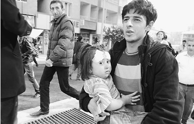 一名土耳其男子抱著地震中受傷的女孩