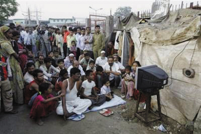印度達哈維貧民窟的貧民聚在一起收看電視