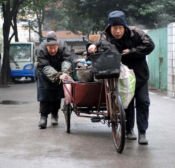 伏萬祥(左)和他的兒子推著裝滿烤梨器具