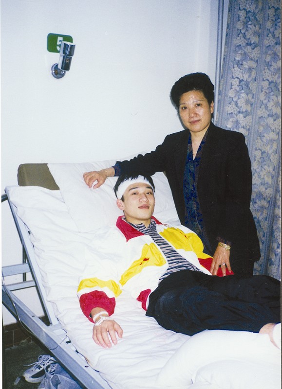 肖海亮跳板磕傷後在醫院休養，床邊是母親陶菊蓉