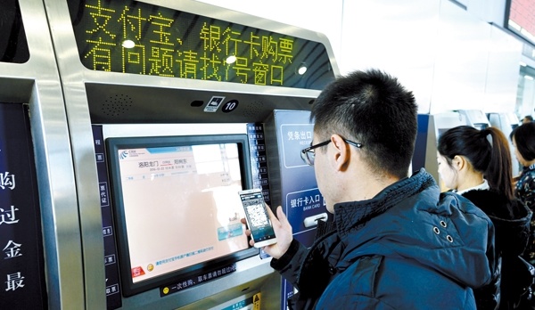 一名乘客在自動售票機旁使用支付寶付款購票