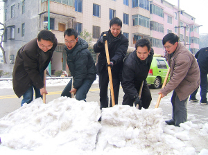 王輝（右二）與同事在大街上剷除積雪