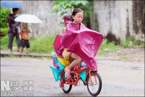 28日瓊海市一位小女孩冒雨騎行
