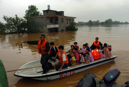 九江市武警支隊戰士在潰決的青湖圩內駕駛衝鋒舟轉移民眾