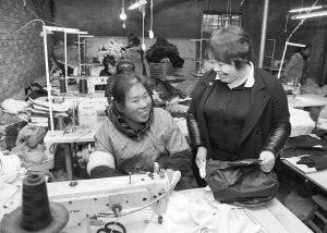 在昊騰服飾有限公司的生產車間，賈茹（右）與職工交流。