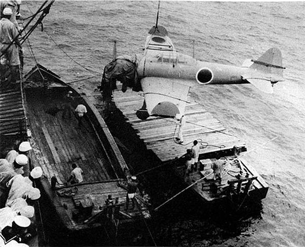 正在港口吊裝的 A6M2 21 型，特徵是摺疊的翼尖