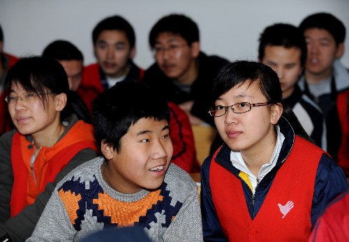 盲童學校的學生(前左)在和志願者交流