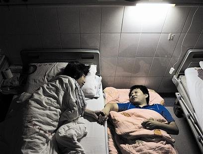 趙瀟將摺疊床擺在母親病床邊陪她入睡。