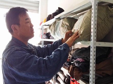 王峰查看架子上堆放的捐助物資。