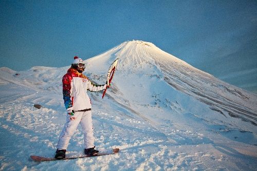 索契冬奧會火炬手在阿瓦恰火山前展示火炬