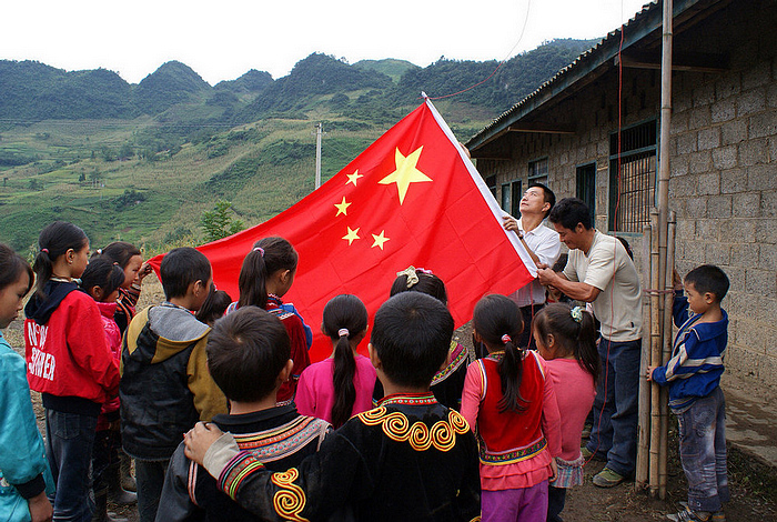 周正軍李安均老師和孩子一起升起五星紅旗