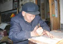 楊洛書老人在刻制木版年畫。