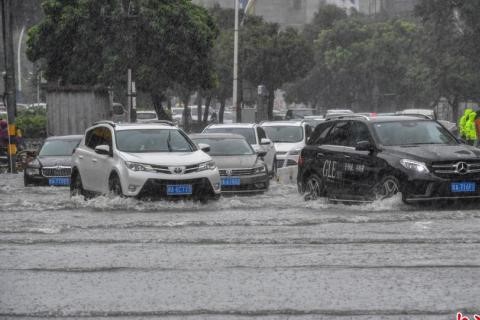 車輛涉險通過海口市龍華路積水路段