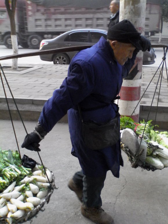 老農挑擔蔬菜上街賣