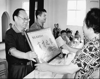 燕振昌同志（左一）為育才之家頒發獎牌。